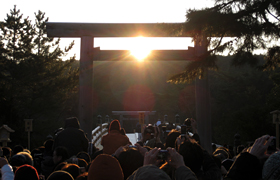 鳥居の中央から輝く太陽